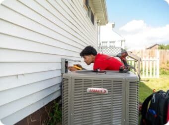 Harris technician installing HVAC condenser unit