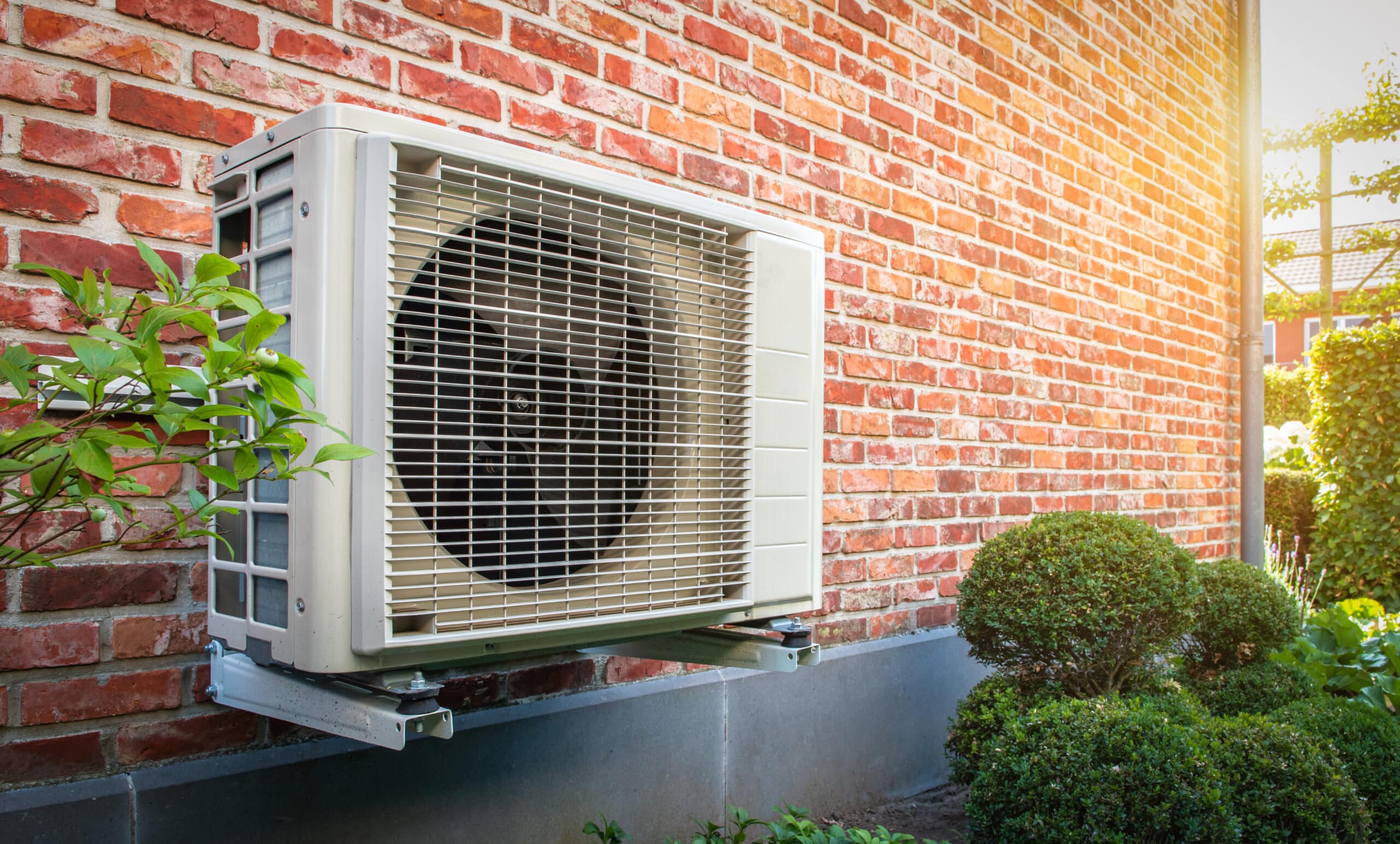 Mounted heat pump against a brick wall