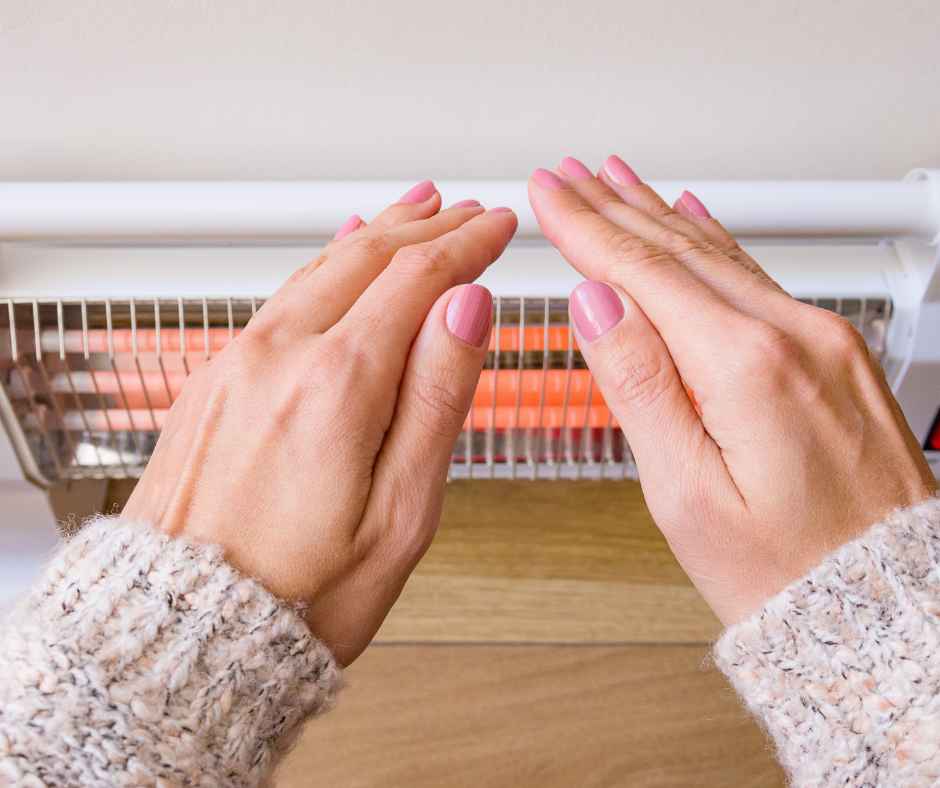 Warming hands by a heater